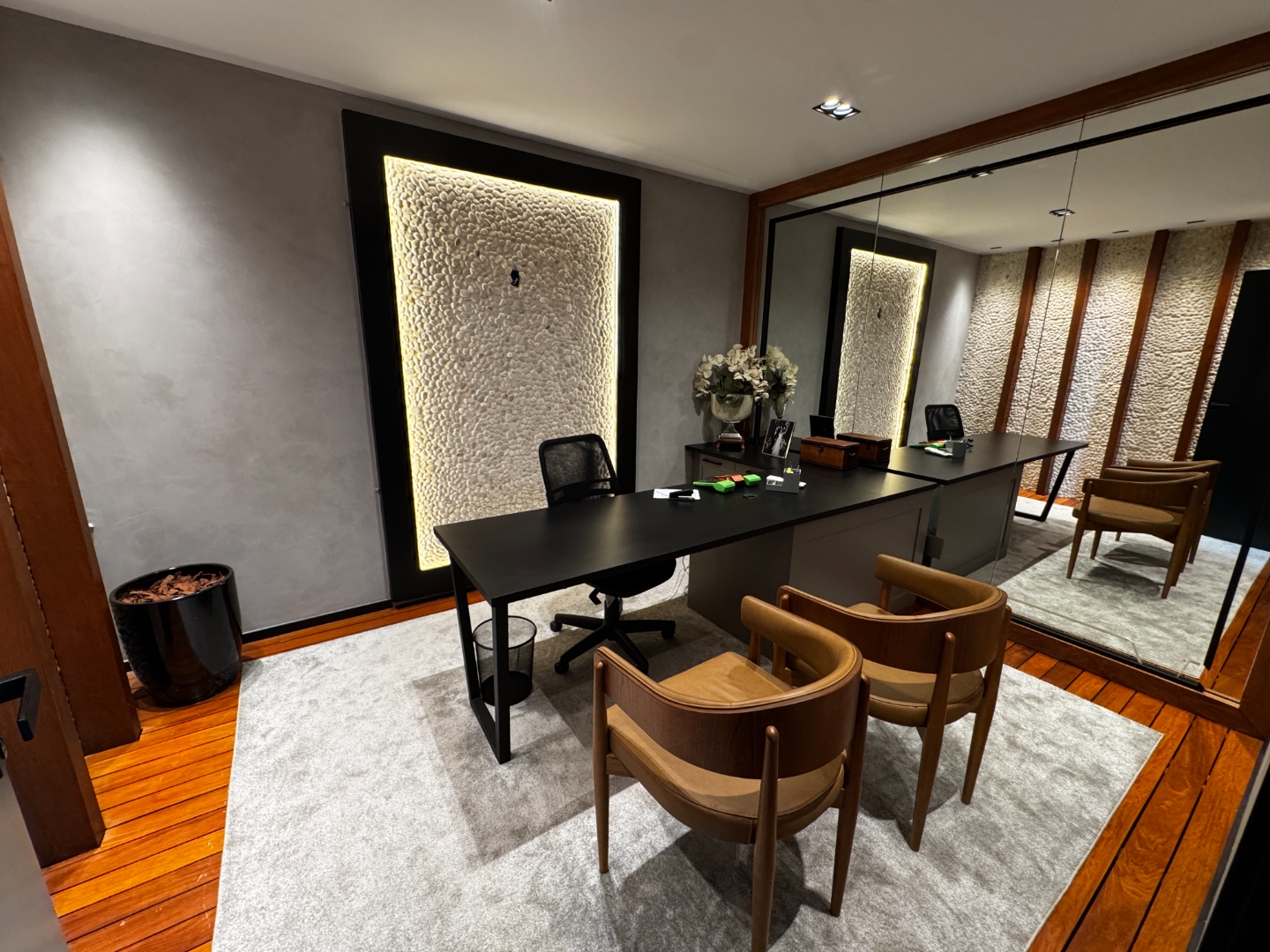 Sala de orçamento — mesa moderna, parede de pedra retroiluminada